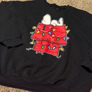 Peanuts crewneck sweatshirt features Snoopy and his doghouse w/Christmas lights!